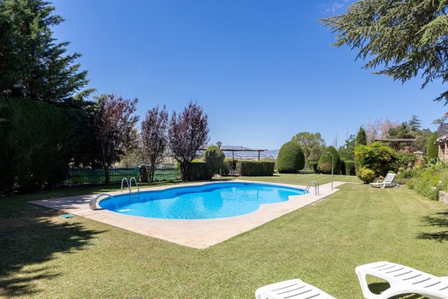 Amplia piscina con jardines