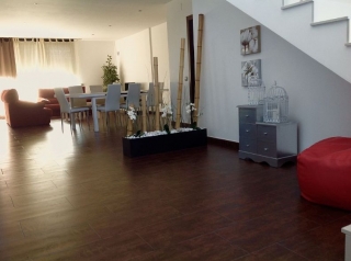 Sala de estar con mesa y sillas junto a los sillones rojos