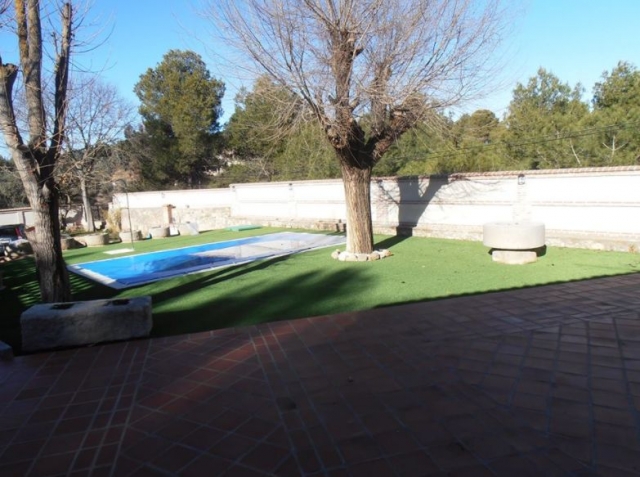 Vistas de la zona de piscina rodeada de espacios verdes