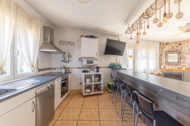 Cocina con barra y tele 