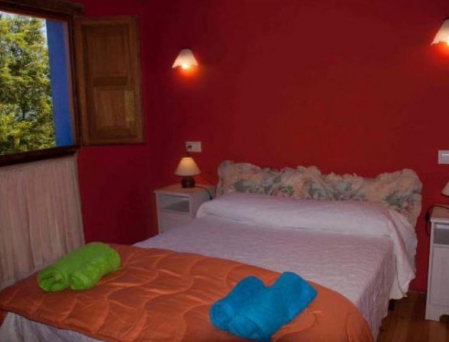 Dormitorio con cama de matrimonio y toallas de colores