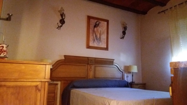 Dormitorio de matrimonio con cabecero de madera