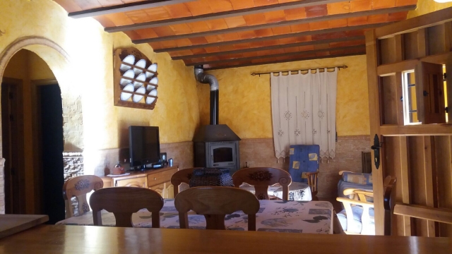 Sala de estar con mesa y chimenea en esquina