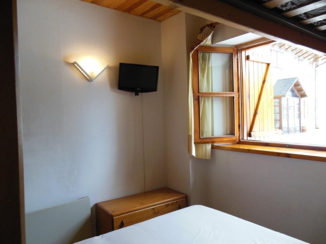 Dormitorio con cama de matrimonio junto a la ventana