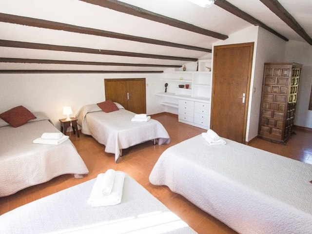 Dormitorio abuhardillado con varias camas