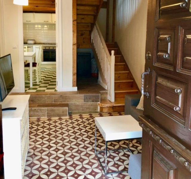 Sala de estar con tele de plasma y sillones delante