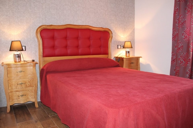 Dormitorio de matrimonio con colcha burdeos