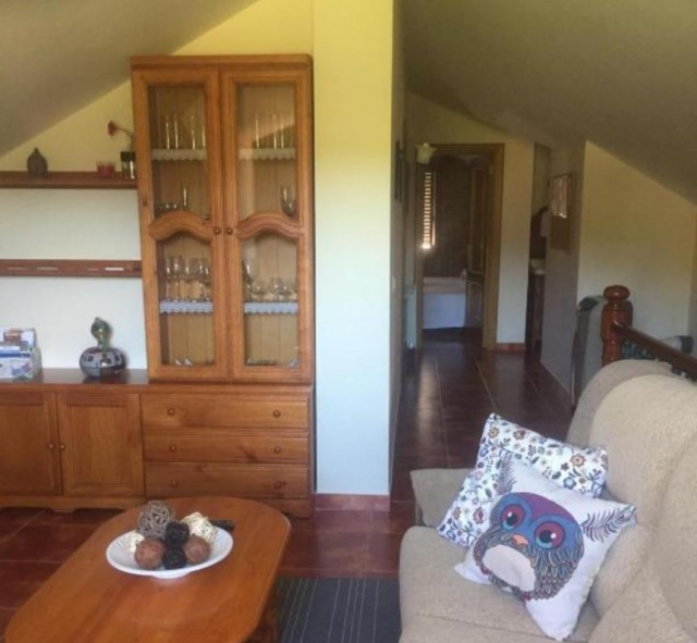 Sala de estar con sillones y mesa de madera con mueble al lado