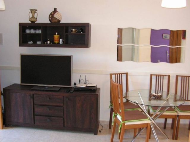 Sala de estar con tele de plasma y mesa