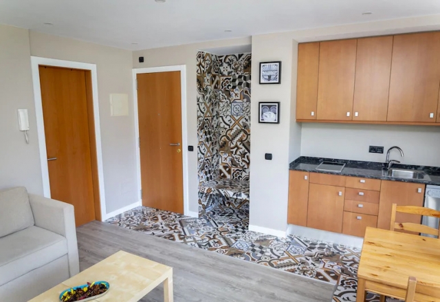 Sala de estar con sillones y cocina a un lado