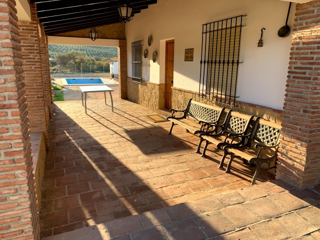 Vista de porche exterior con piscina al fondo