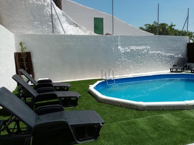 Amplia piscina con hamacas