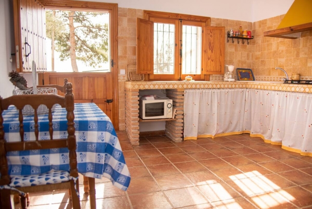 Cocina con mesa y ventanas