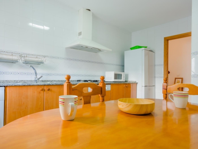 Cocina con mesa delante 