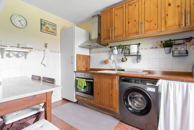 Cocina con lavadora y mesa