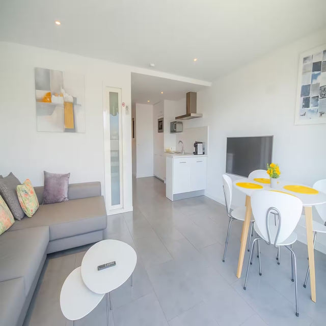 Sala amplia con mesa y tele