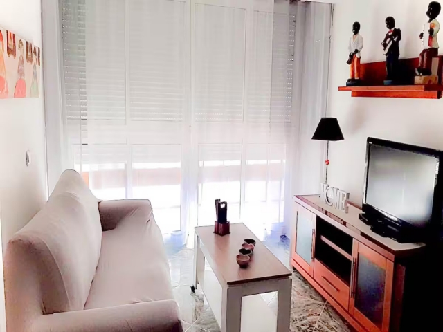 Sala amplia con sofa y tele