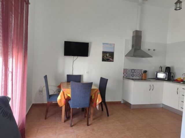 Cocina con mesa y tele