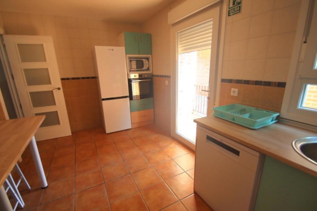 Cocina con mesa y salida