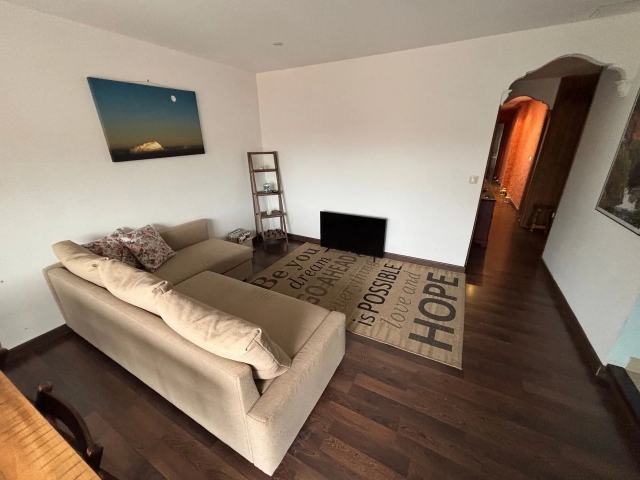 Sala amplia con sofá y tele