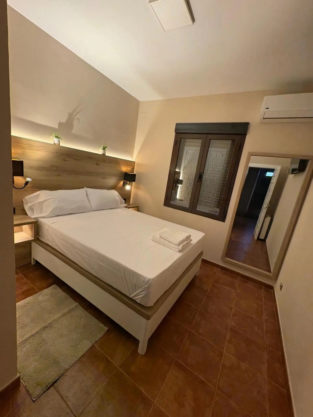 Cama de matrimonio y espejoa pie de ventana.jpg