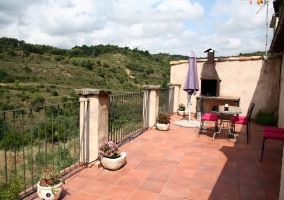 Terraza con mesas y barbacoa