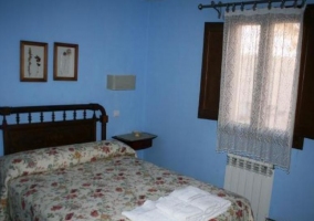 Dormitorio de matrimonio en azul y colcha de flores