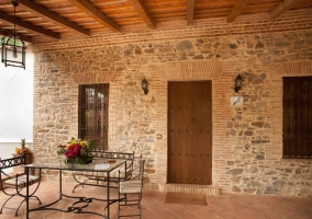 Puerta de acceso a la casa rural con mesa y sillas de forja