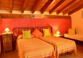 Dormitorio con camas individuales y techos de madera de la casa rural