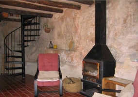 Mesita con sillas para almorzar con paredes de piedra en la casa rural