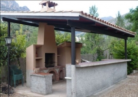 barbacoa con horno árabe cubierta por un techo