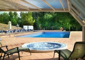 Piscina con jacuzzi y hamacas