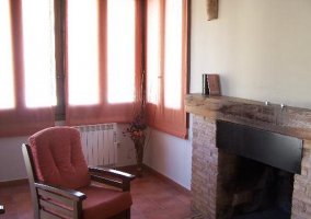 Butaca de la sala de estar con chimenea de la casa rural
