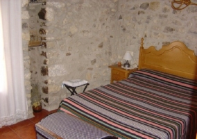 Habitación de matrimonio con pared de piedra