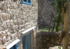 Fachada de piedra trasera con ventana azul