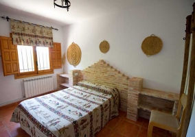 Dormitorio con cabecero de ladrillo