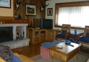 Sala de estar con chimenea y una mesa de madera auxiliar