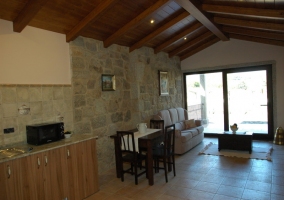 Salón comedor con pared de piedra