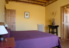 Cama de matrimonio con colcha morada