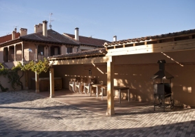 Patio exterior con barbacoa y muebles y jacuzzi al fondo