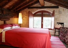 Dormitorio de matrimonio en buhardilla con sillones delante