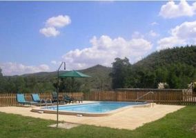 Piscina con zona solárium y hamacas