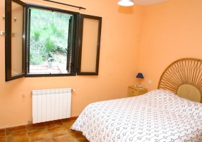 Dormitorio con cama de matrimonio y paredes naranjas