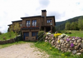 Fachada con camino y muro de piedra