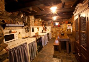 Dormitorio en madera con paredes de piedra de la casa rural
