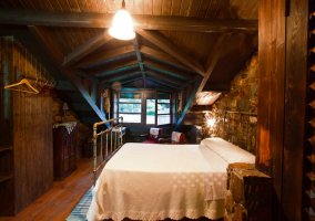 Sala de estar y comedor con paredes de piedra de la casa rural