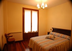 Dormitorio con cama de matrimonio y balcón