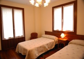 Dormitorio con dos camas y varias ventanas