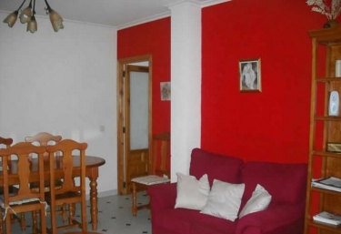 Sala de estar en madera y paredes en rojo con mesa