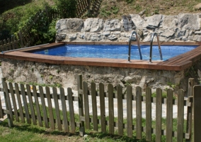 Piscina de madera y piedra vallada